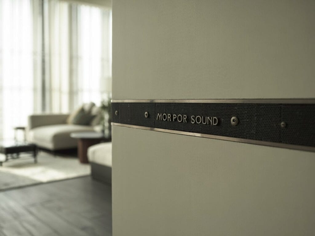 A detail shot of a seamlessly integrated speaker or sound system within the wall of a modern townhouse.